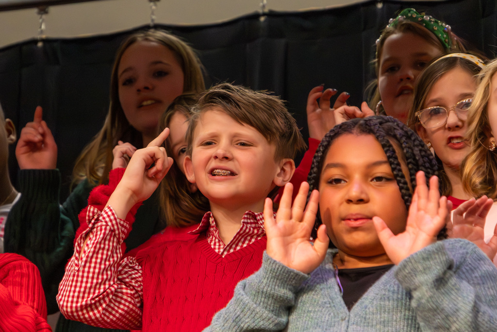 Two elementary students singing and gesturing