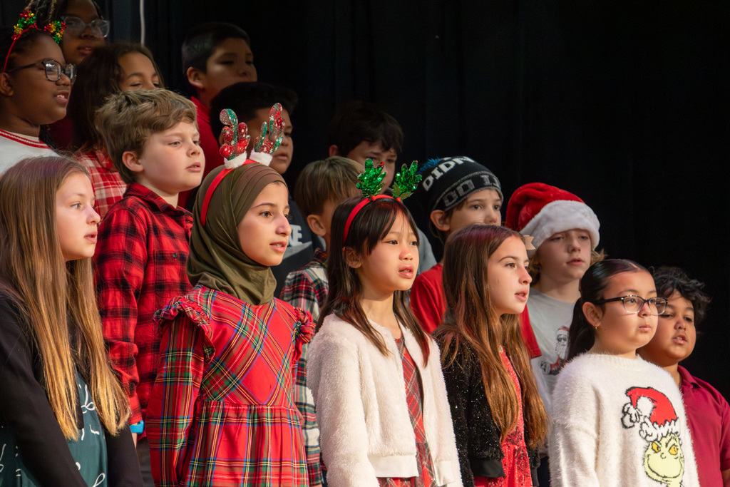Group of elementary students in holiday attire singing