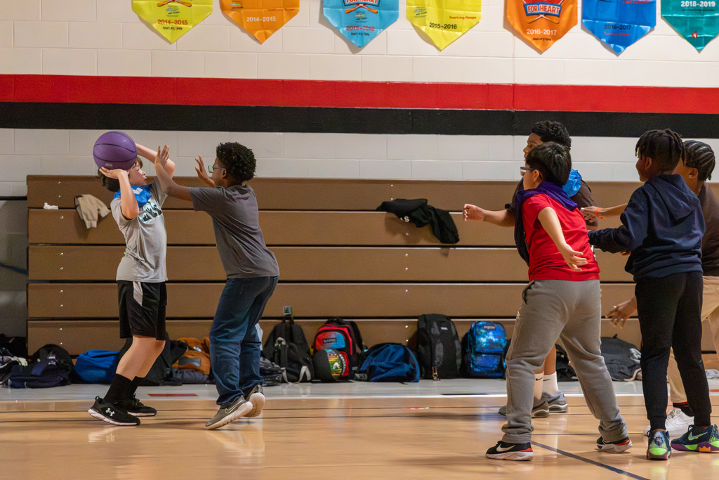 One student looks for teammates to pass to as they are guarded closely