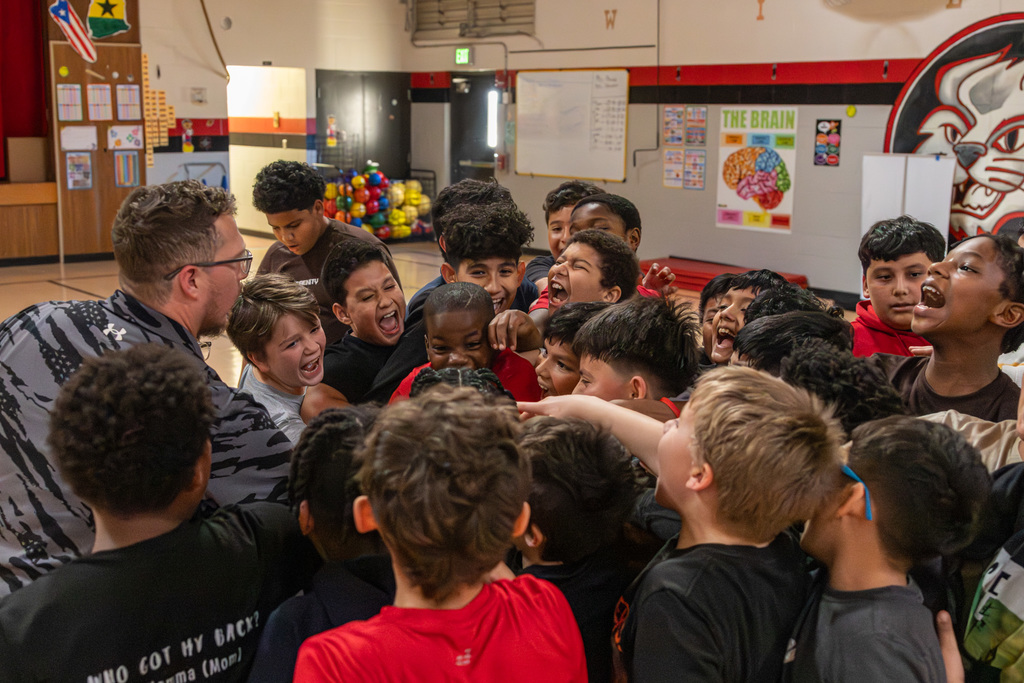 Group of middle school basketball players in a huddle, cheering