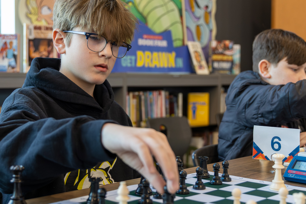 Boy moving a chess piece