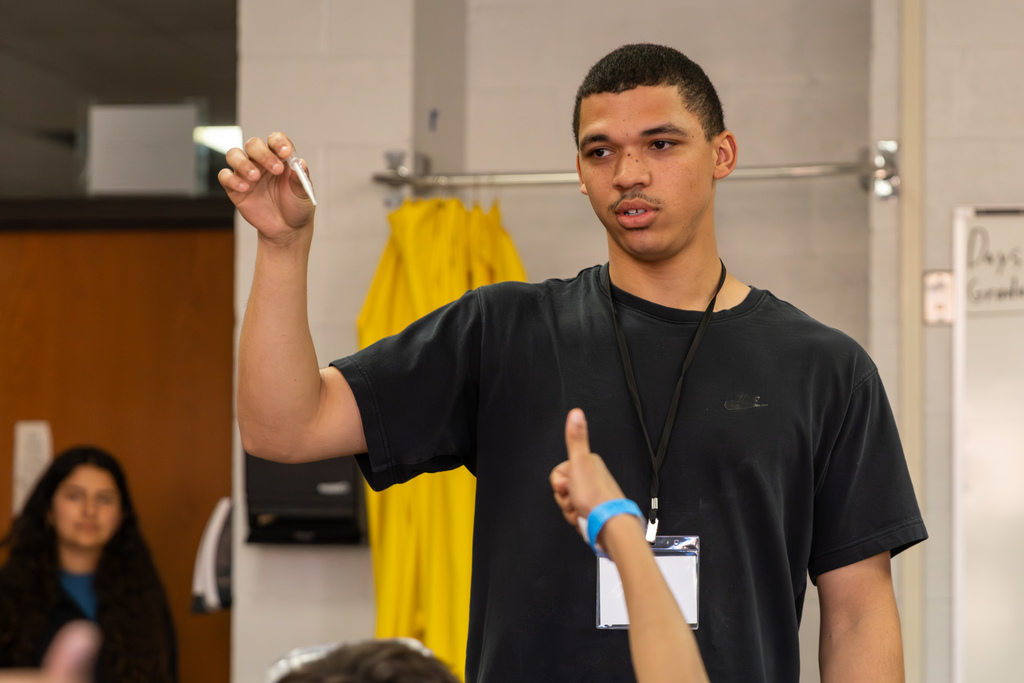 a high school student demonstrating pipette technique