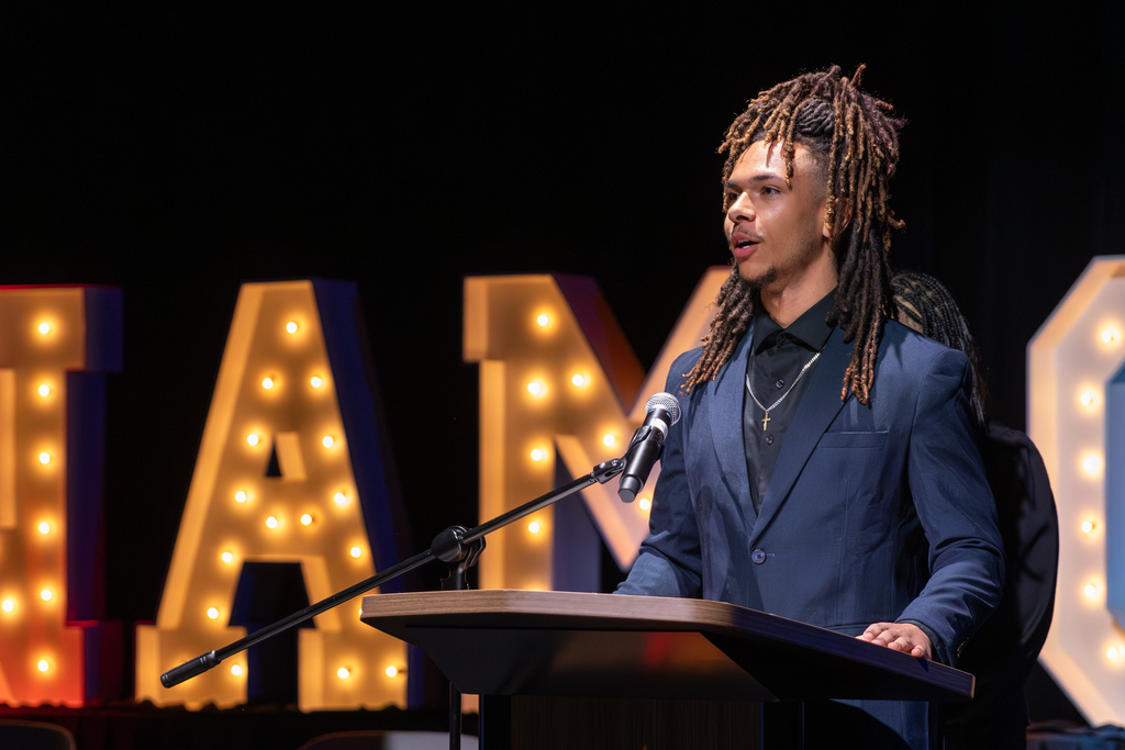 Student emcee speaking at podium