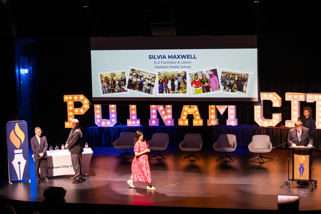 Site Teacher of the Year walking across stage with an award