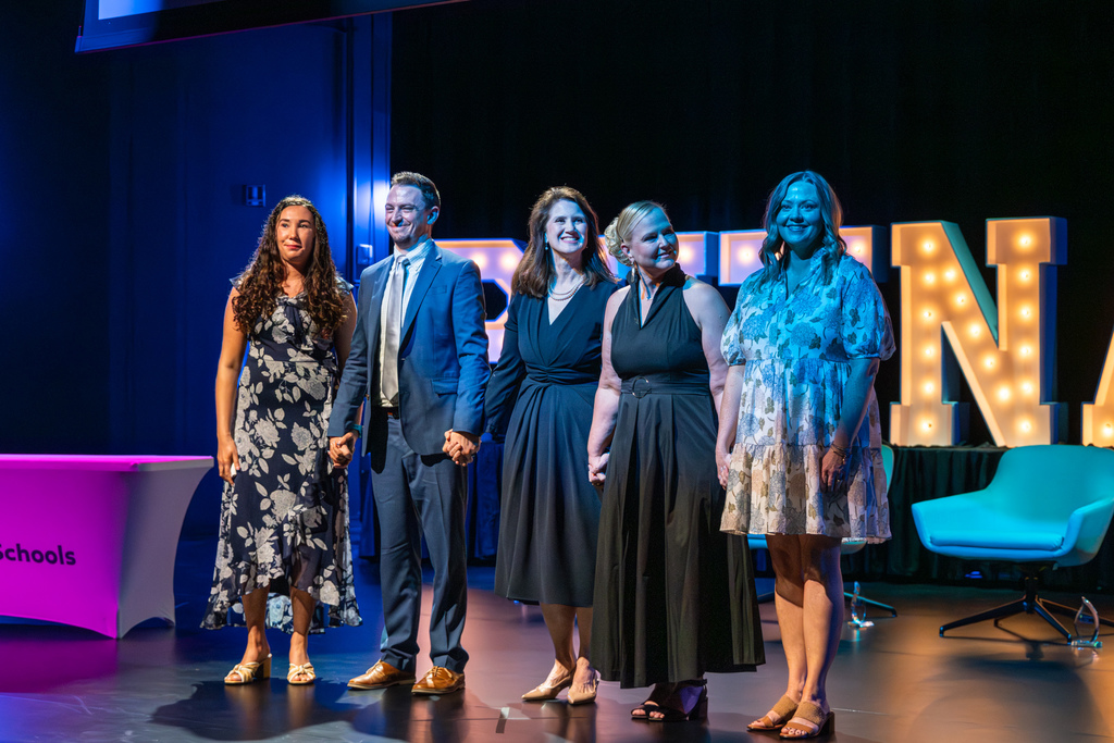 Teacher of the Year finalists holding hands on stage