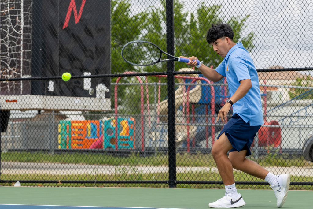 A Putnam City West tennis player steps into a forehand, eyes locked on the ball as it crosses the net.