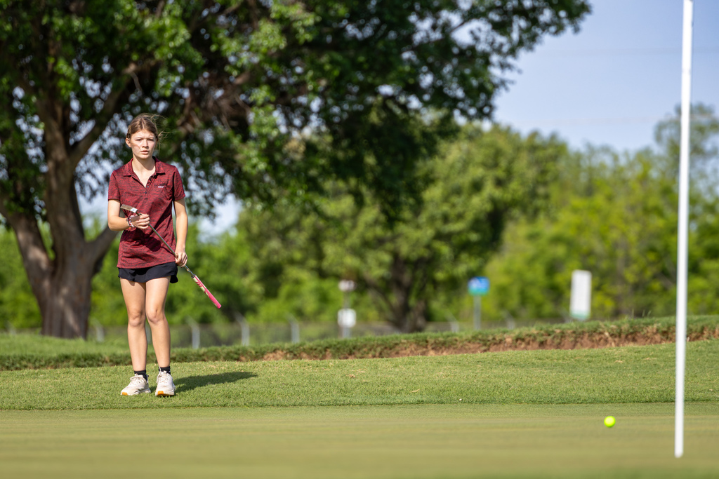 Student golfer watches a putt roll toward the hole on a green at Lake Hefner Golf Club during the OSSAA 6A Girls Regional Tournament.