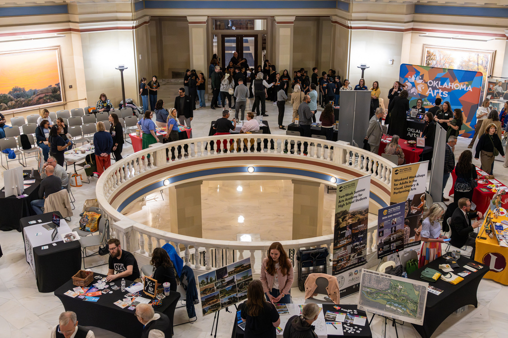 Interior of the Oklahoma State Capitol rotunda during Oklahoma Arts Day, with booths, displays, and attendees gathered around tables.