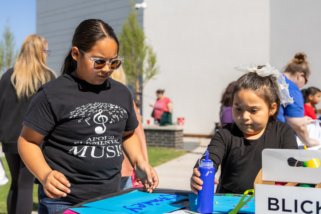 Two students work on a craft activity outside the Centennial Center during the Putnam City Arts Festival.