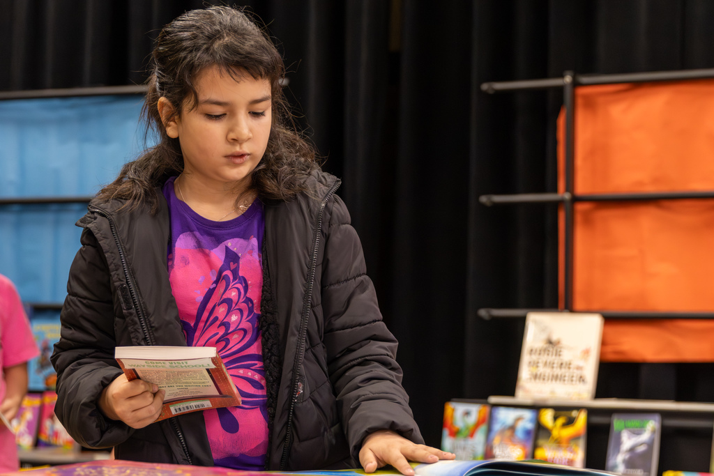 A student browses books on a table during Overholser Elementary’s Free Book Fair.