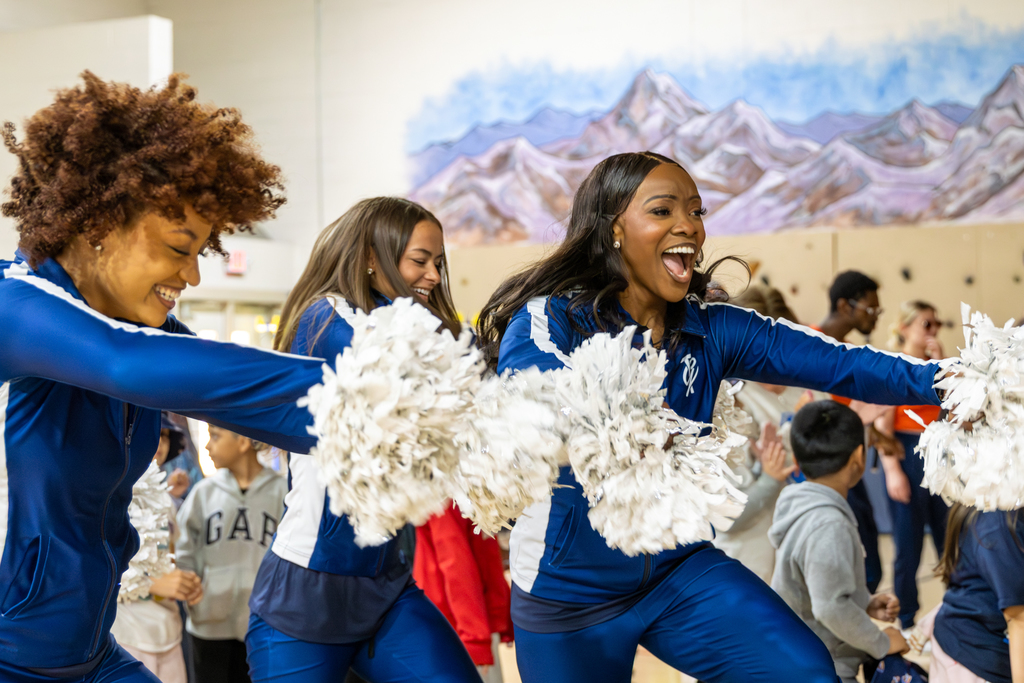 Thunder Girls dance with pom-poms alongside Rollingwood Elementary students during the school’s Thunder Reading Challenge celebration.