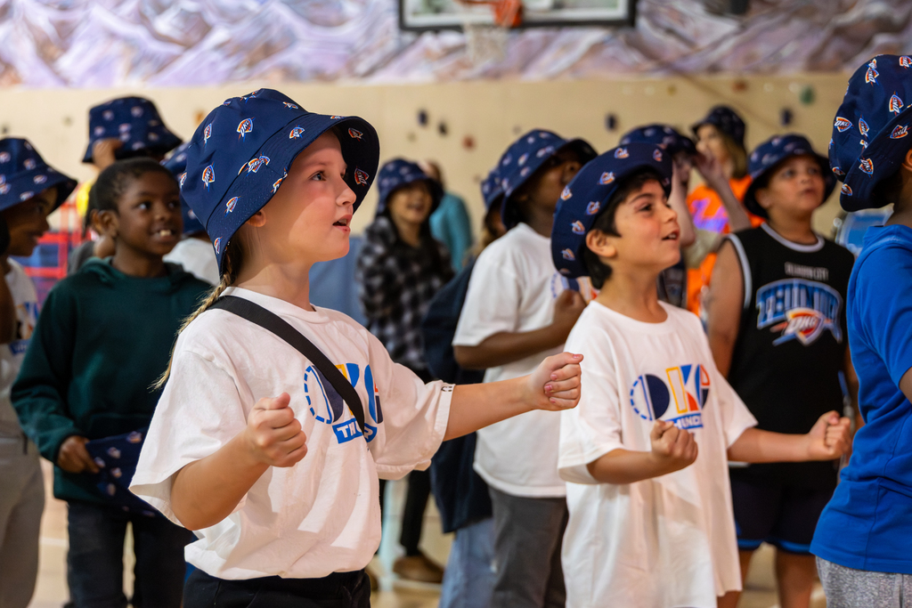 Rollingwood Elementary students dance in the gym while wearing Thunder hats during a celebration with the Oklahoma City Thunder.