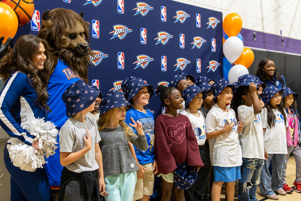 Rollingwood Elementary students pose with Rumble, Thunder Girls and an Oklahoma City Thunder backdrop after winning first place in the Thunder Reading Challenge.