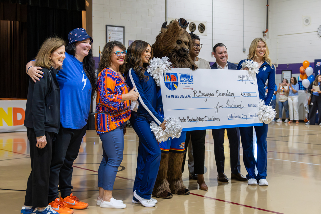 Rollingwood Elementary staff and Oklahoma City Thunder representatives pose with Rumble and a large $5,000 check presented for winning first place in the Thunder Reading Challenge.