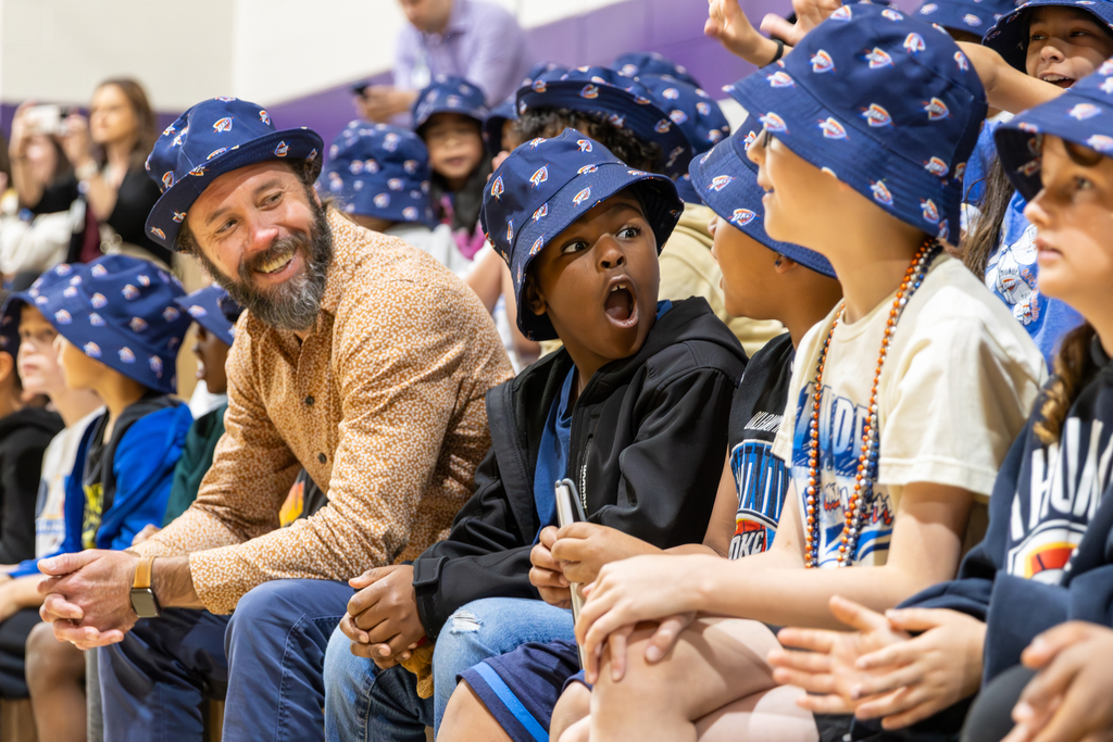 Rollingwood Elementary students in Thunder hats react excitedly from the bleachers during their Thunder Reading Challenge celebration.