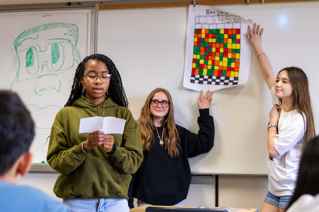 Hefner Middle School students present a handmade board game called “Hot Streak” at the front of the classroom.