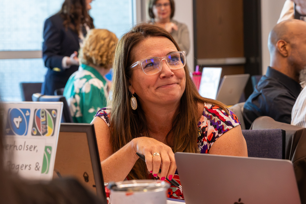 An administrator smiles while listening to a colleague during the workshop.