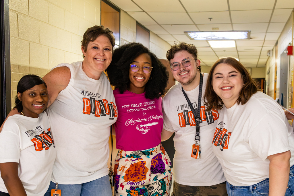 Five Putnam City High School employees smile together in a hallway on the first day of school.