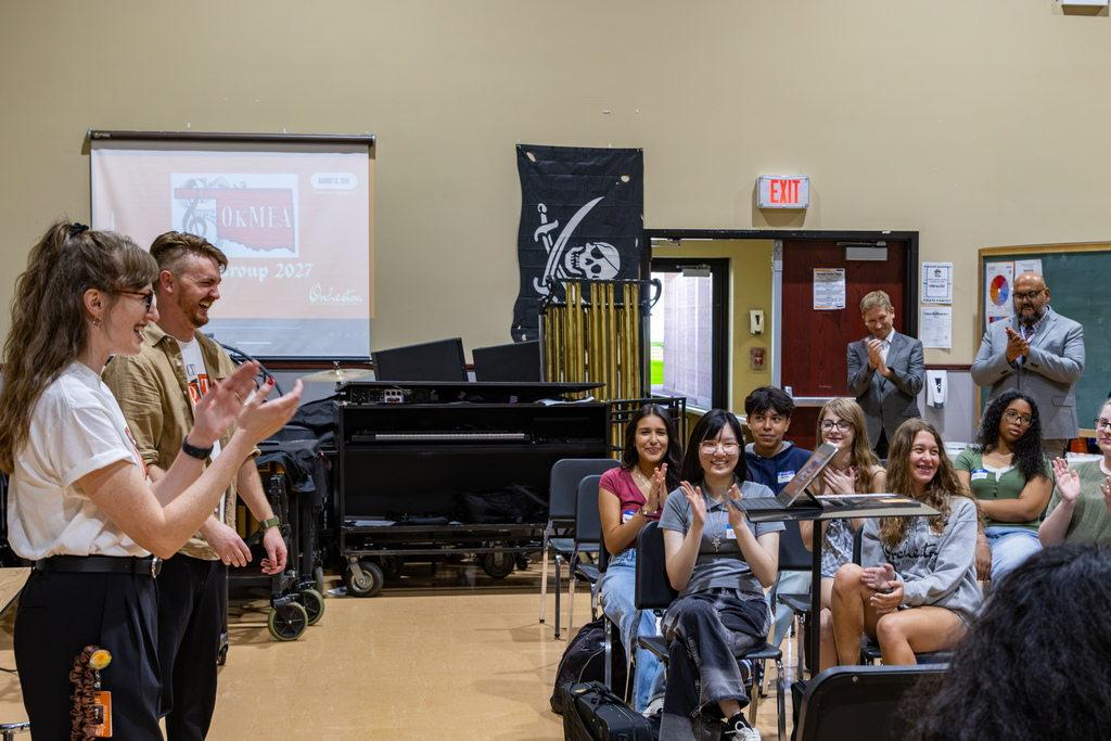 Students and staff in the Putnam City High School orchestra room applaud after the Symphony Orchestra receives a surprise announcement that it was selected to headline the 2027 OkMEA Winter Conference.
