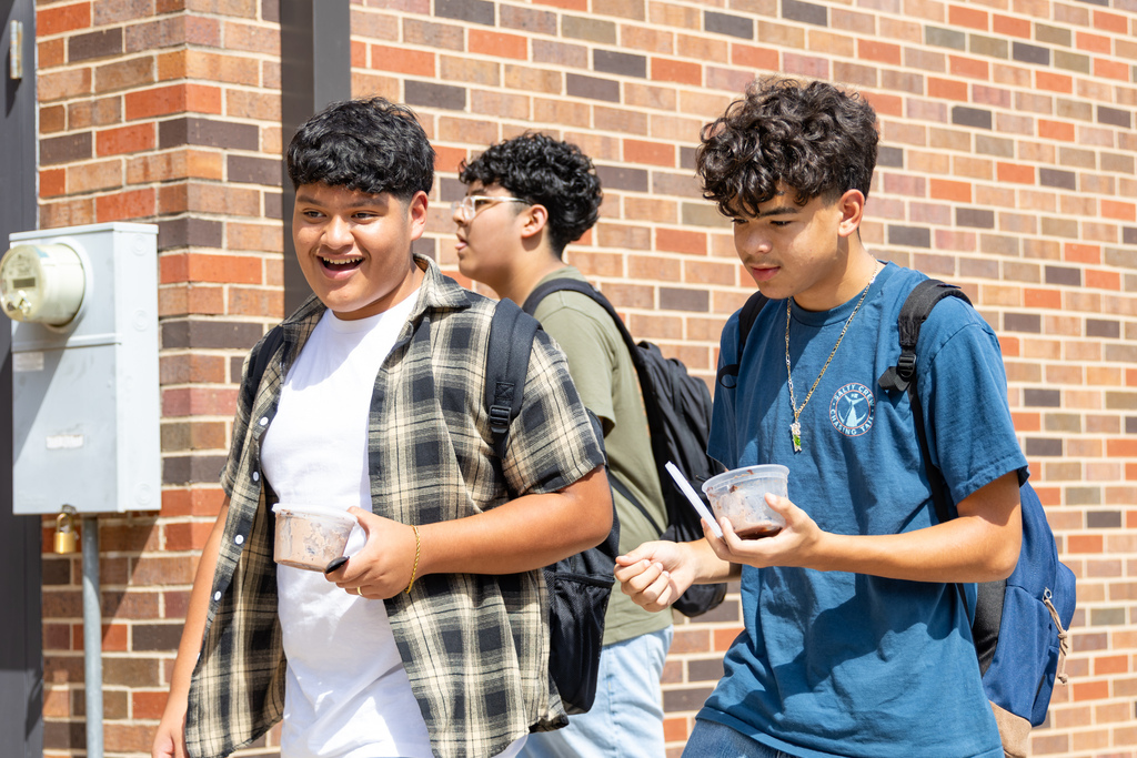 Two Putnam City West students walk together with food during the lunchtime Back to School Bash.