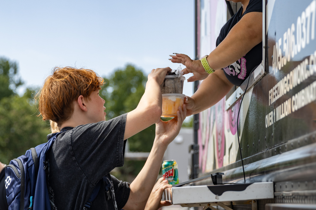 A Putnam City West student receives food from a food truck window during the school’s Back to School Bash.