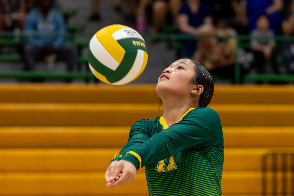 A Western Oaks Middle School volleyball player prepares to pass the ball, looking upward as the ball hangs just in front of her face.