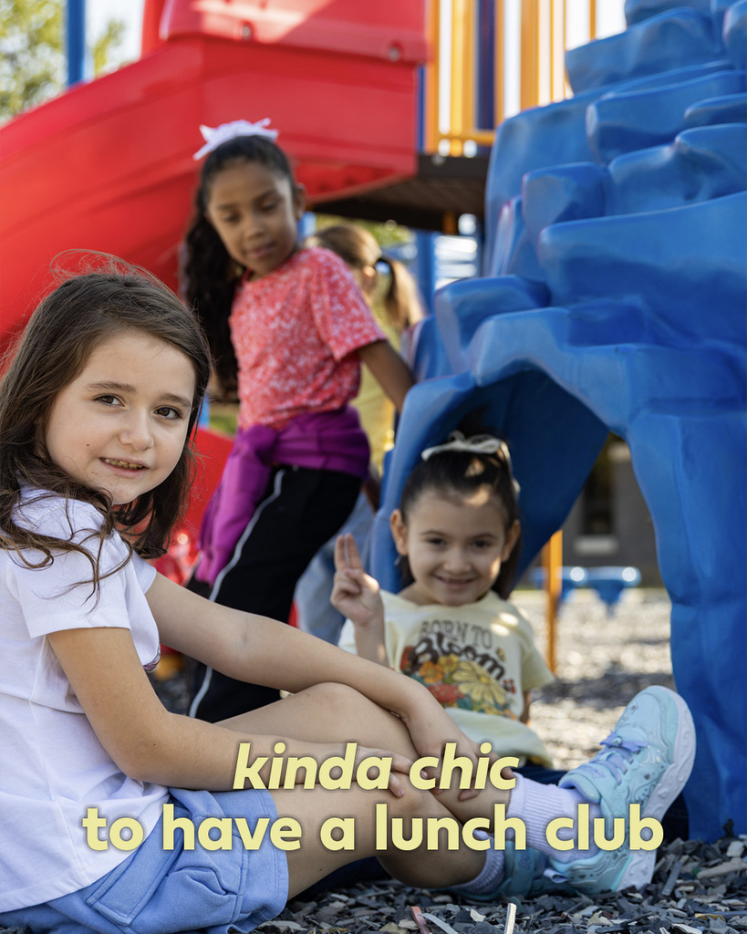 Three students sit together underneath playground equipment, talking during recess. Text reads, “kinda chic to have a lunch club.”