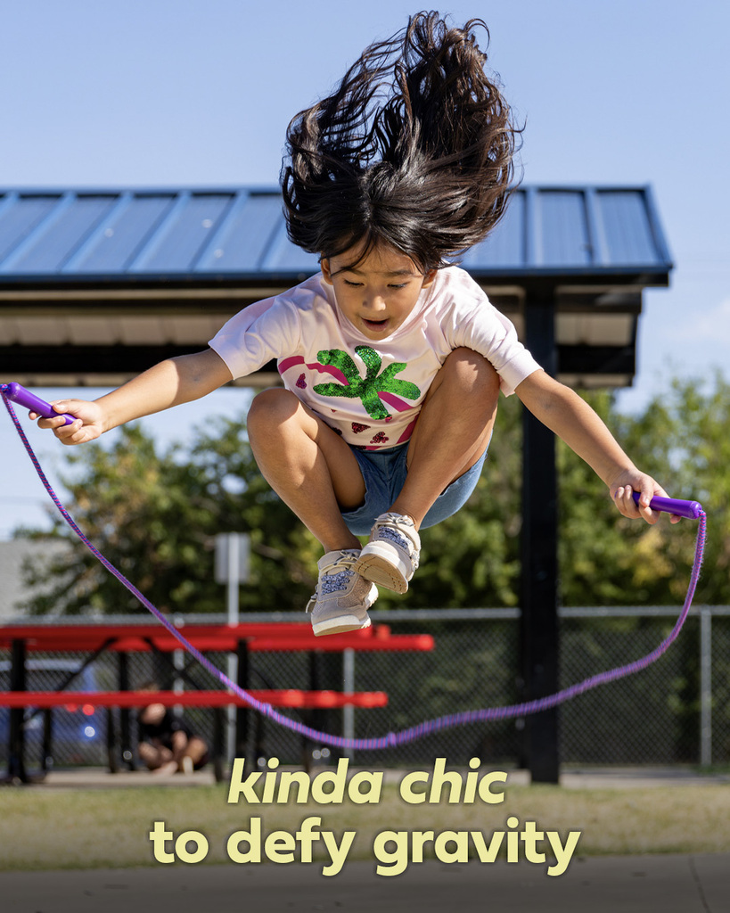 A student jumps rope, captured completely off the ground with her hair flying. Text reads, “kinda chic to defy gravity.”