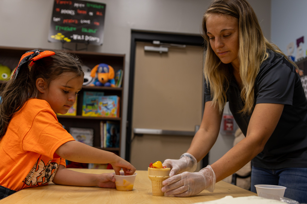 district dietician and student fill fruit cup