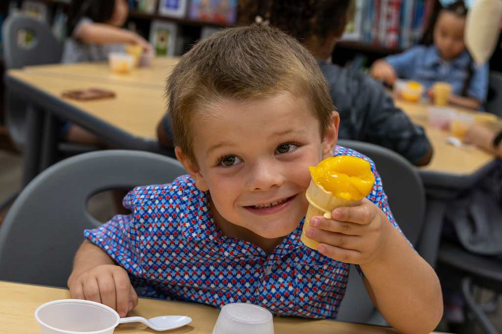 student holds up fruit cup