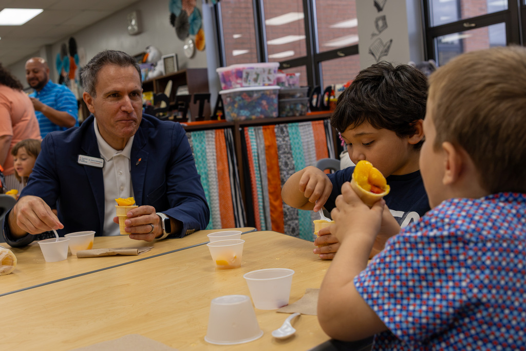 superintendent rodrequez and two students talk at table
