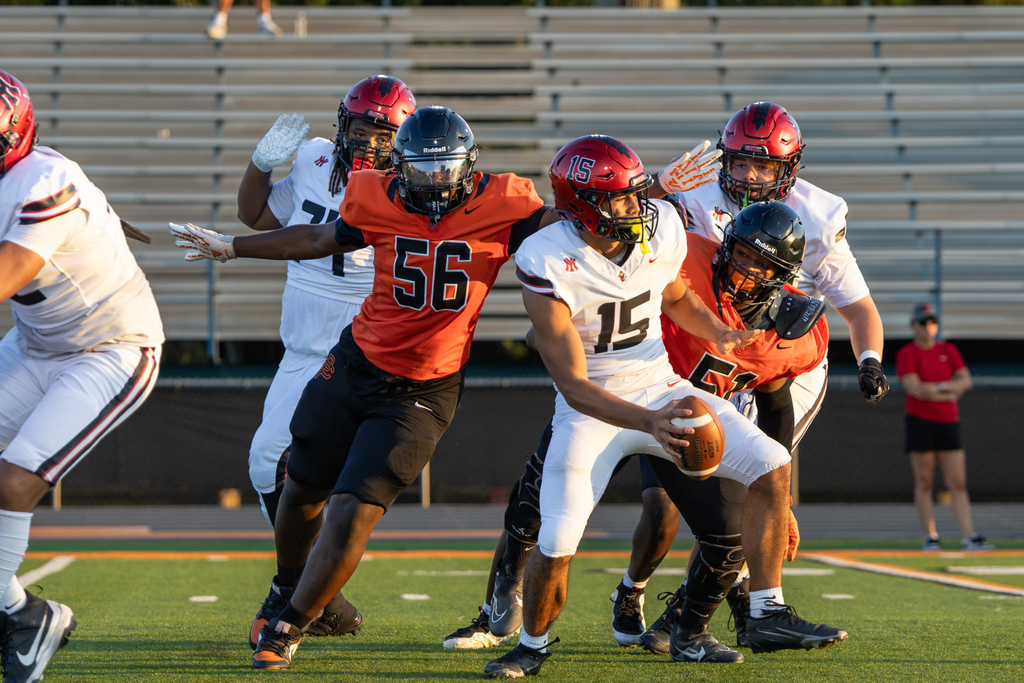 Putnam City High defenders pursue Yukon quarterback No. 15 as he runs with the football.