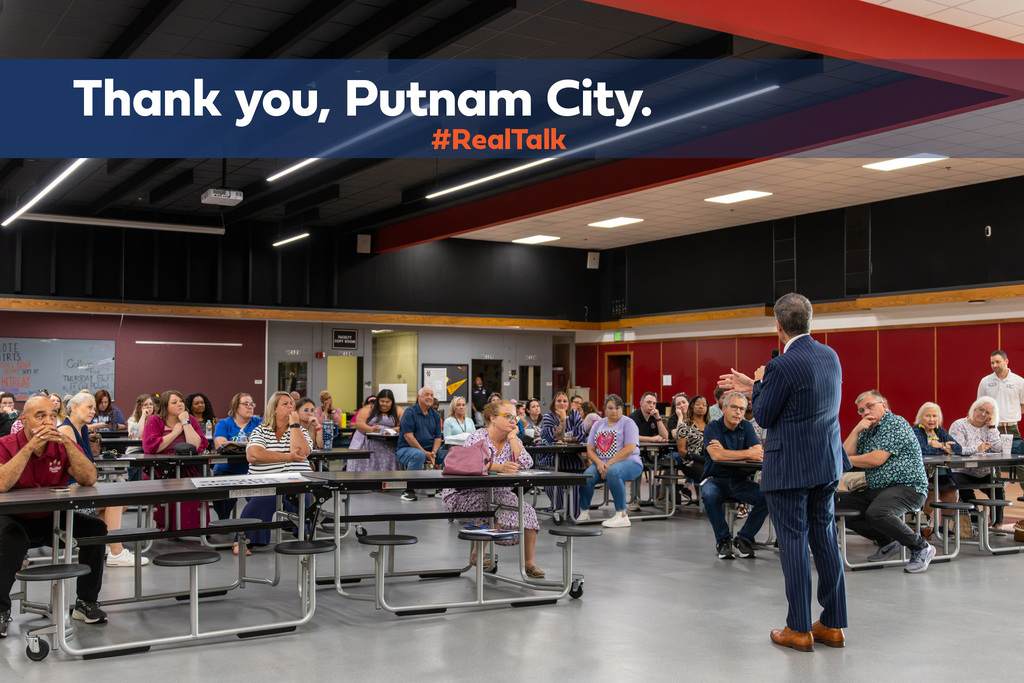 Dr. Rodrequez addresses a seated crowd at PC North. Text across the top says, "Thank you, Putnam City. #RealTalk"
