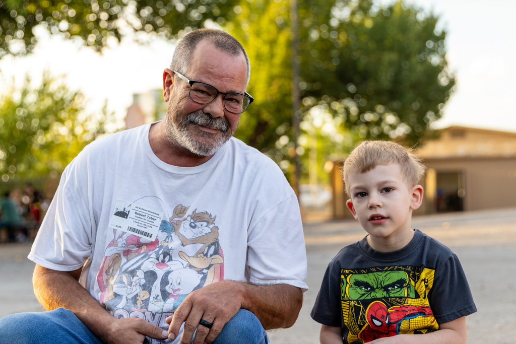 An older man and a young student sit together outside DD Kirkland during Goodies with Grands.