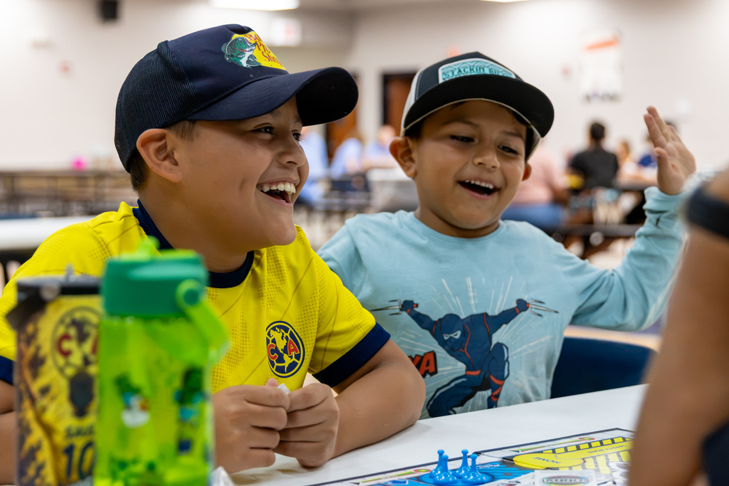 Two boys laugh together while playing a board game during Central Elementary’s Family Game Night.