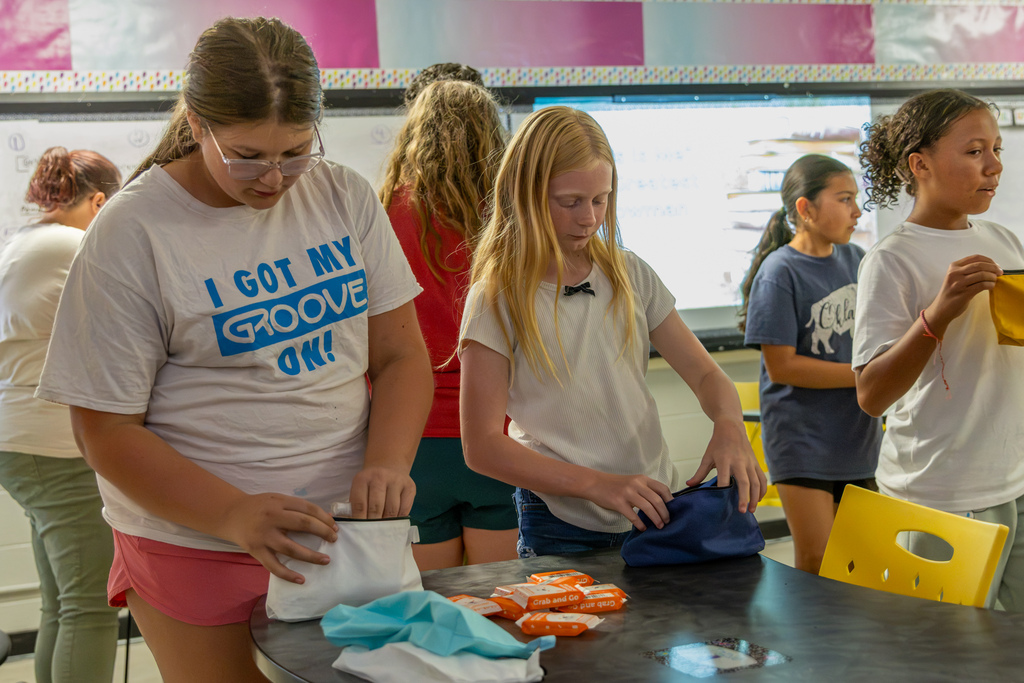 Western Oaks Middle School softball players fill hygiene bags with individually packaged personal care items during their service project.