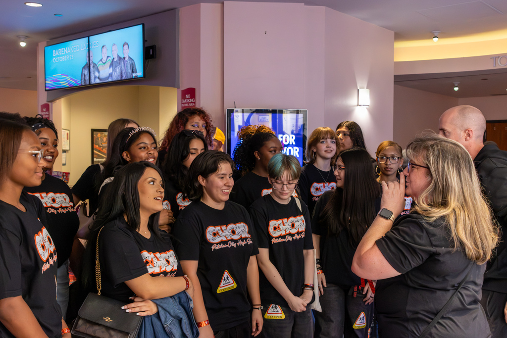 Putnam City High School choir students gather in the Riverwind Casino lobby around an adult speaking to the group before the Foreigner concert.