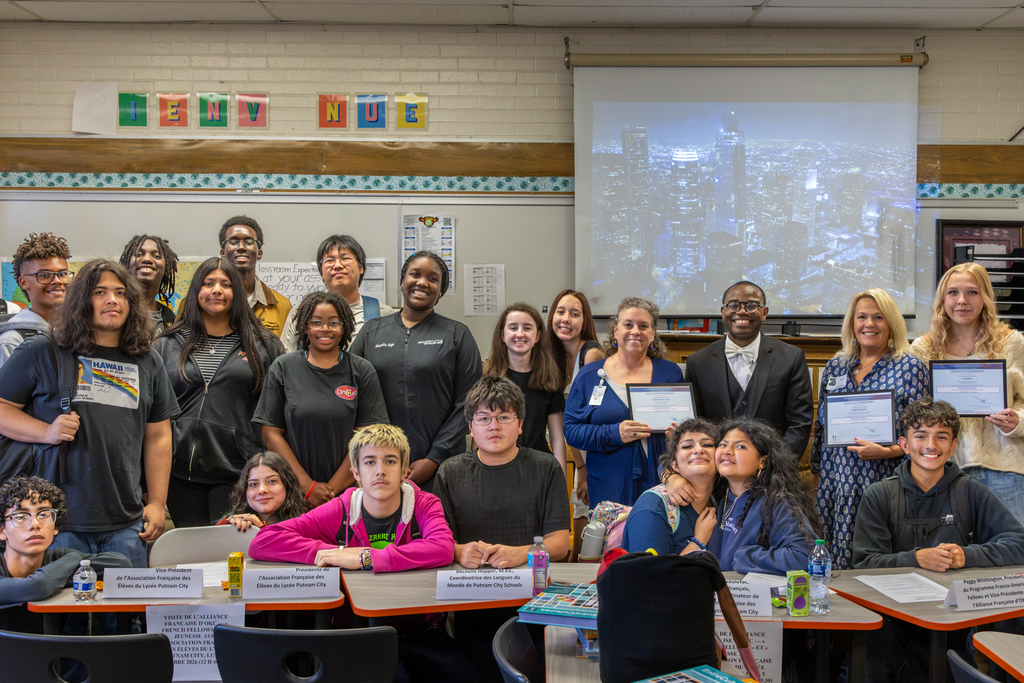 Students, staff, and Alliance Française guests pose together while several participants hold certificates of recognition.