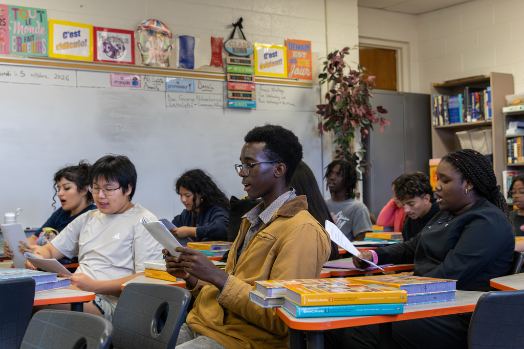 Putnam City High French students read from printed sheets together during the Alliance Française visit.