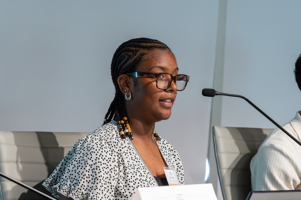 Close-up of student panelist Zoe Lain speaking into a microphone during the student-led presentation.