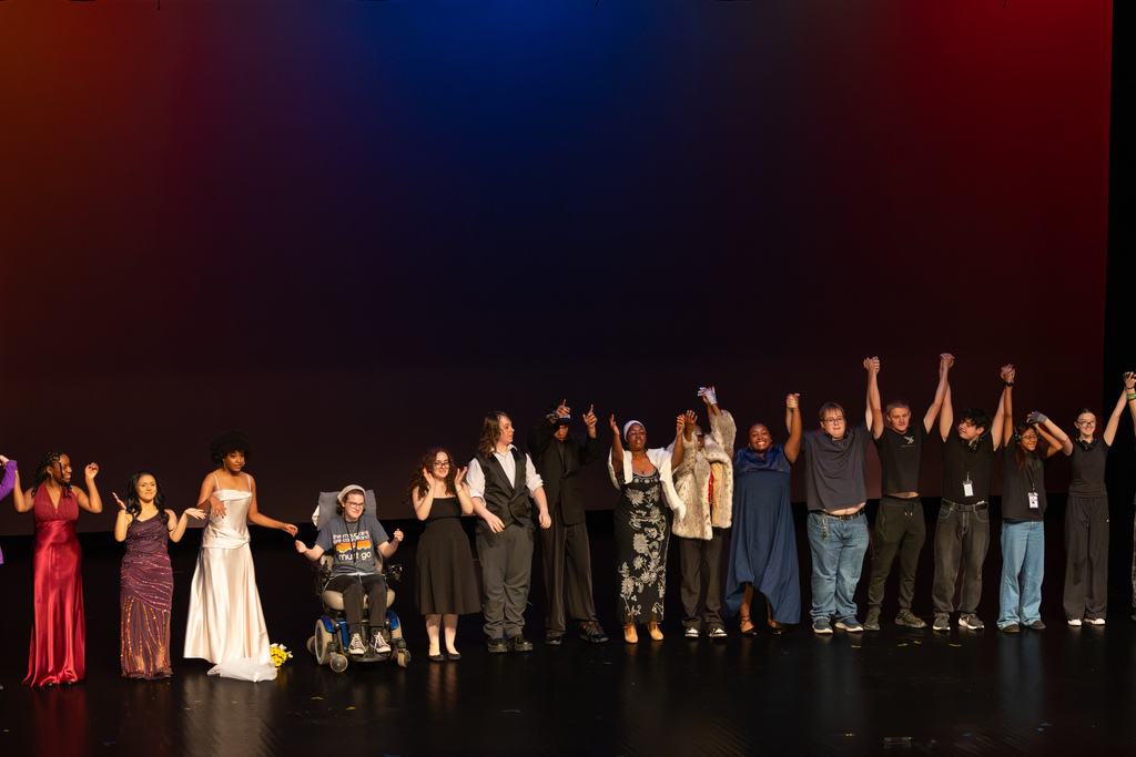 The full cast and crew of the PC High Short Play Festival hold hands and bow together during curtain call.