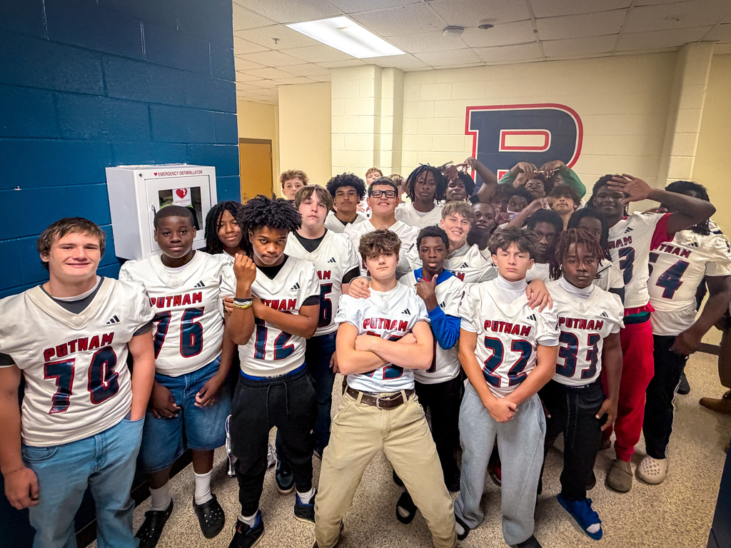 A team wearing white jerseys with numbers 70, 76, 12, 22, 33, 91, and 4 stands in a corridor.