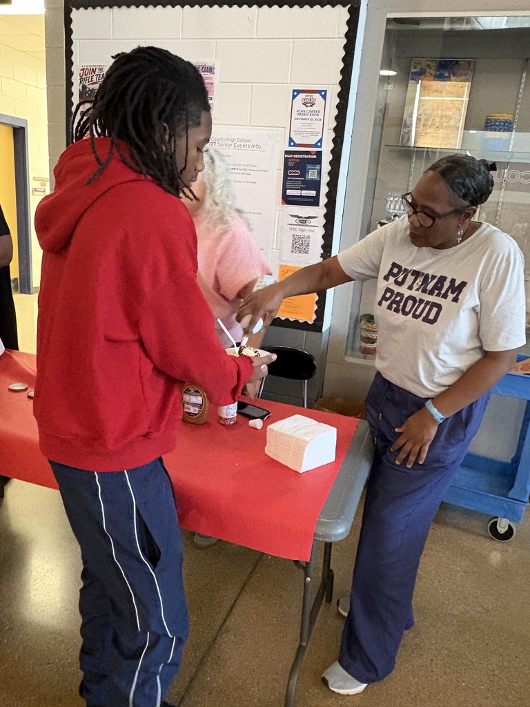 Mrs. Farley is adding the whipped topping to the sundae