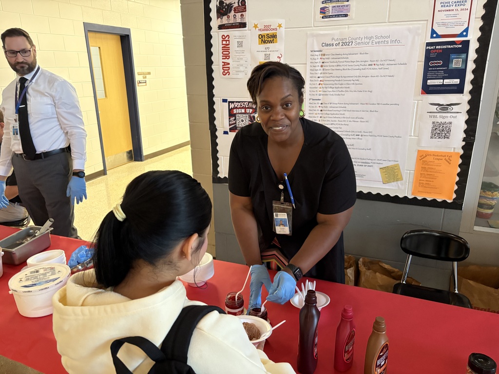 Mrs. Jones assisting student with ice cream sundae toppings.