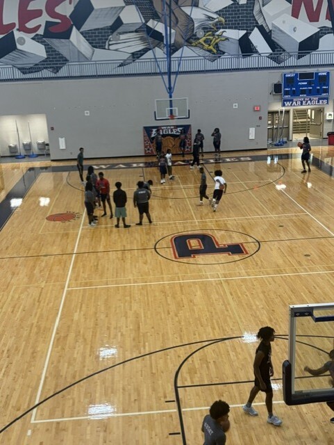 Students in gym playing basketball