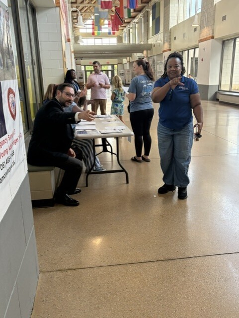 Directions being provided to parent by Mr. Patrick and teachers holding discussions with other parents