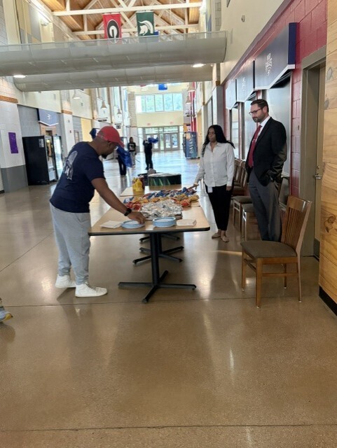 administraton and counselor speaking with parent at food table