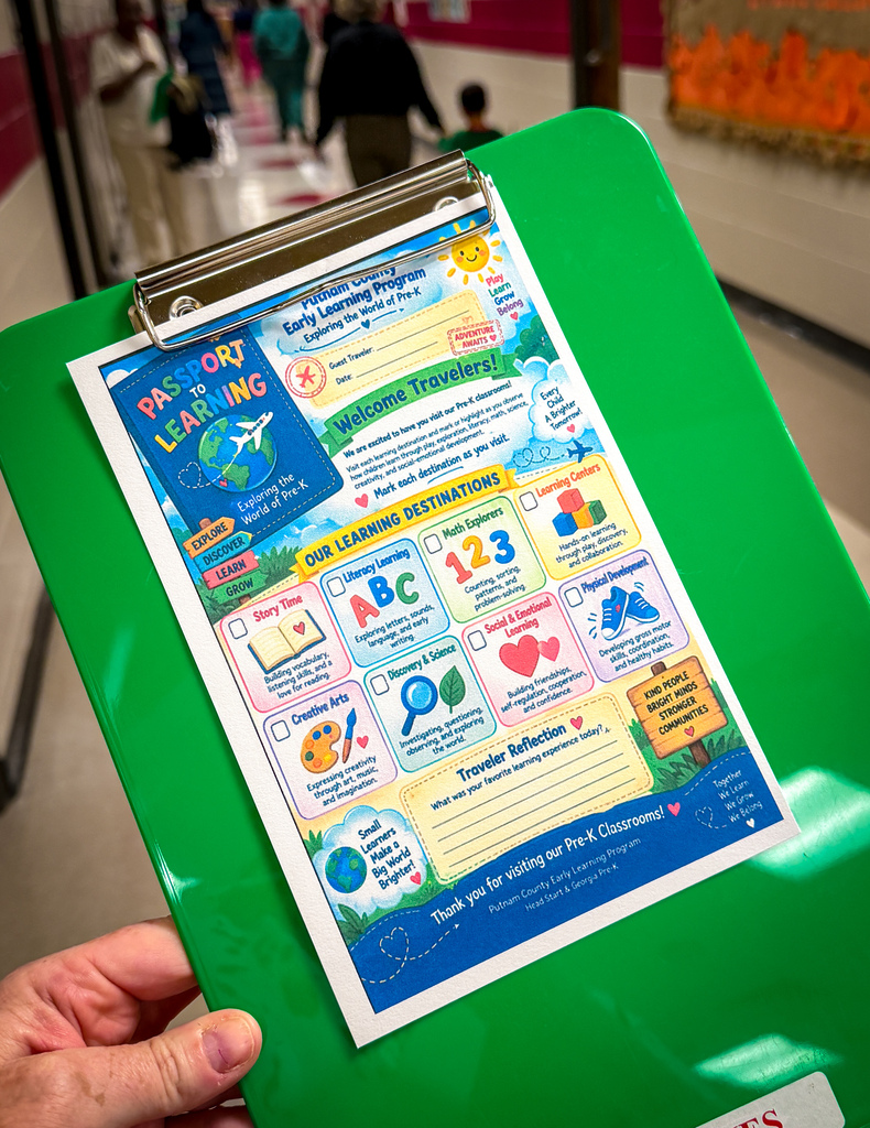 A green clipboard displays a colorful flyer about early learning. The flyer features a map, destinations, and icons.