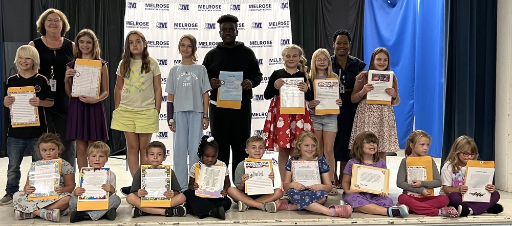 Picture of 17 students (boys and girls) and 2 adults holding their Terrific Kid Certificates