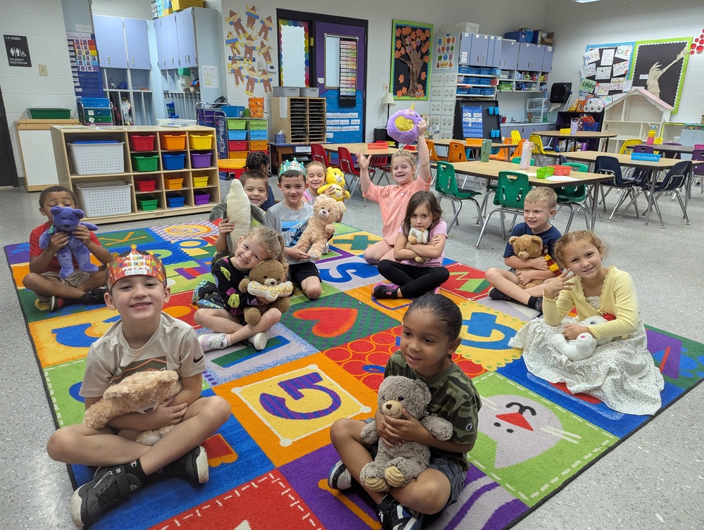 picture of kindergarten classroom with 12 boys and girls holding stuffed animals